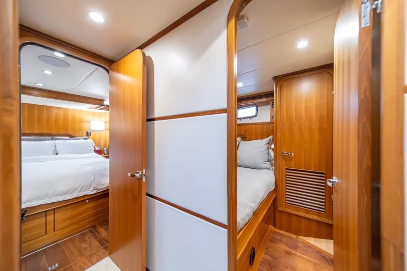 Smile Smile Smile Yacht Photos Pics Luxurious interior of 2022 Outer Reef 720 Motor Yacht with cozy bedrooms and elegant wood finishes.