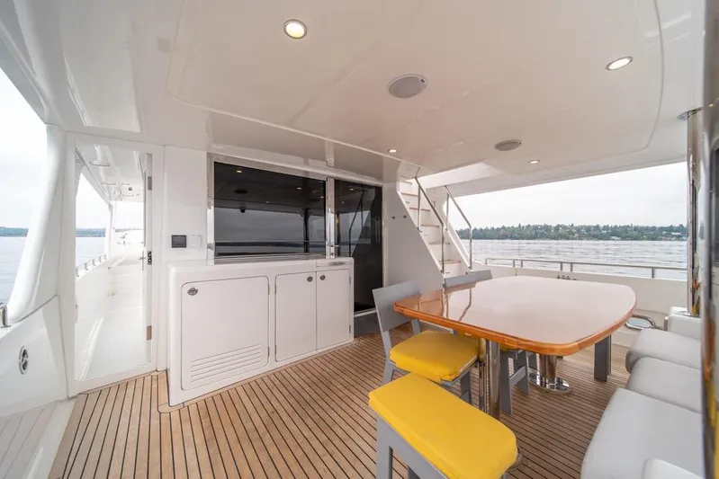 Smile Smile Smile Yacht Photos Pics Luxurious 2022 Outer Reef 720 Motor Yacht deck with dining area and scenic water view.