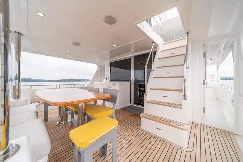 Smile Smile Smile Yacht Photos Pics Luxurious 2022 Outer Reef 720 Motor Yacht deck with dining area and staircase.