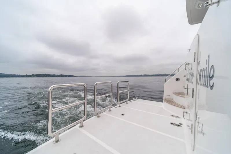 Smile Smile Smile Yacht Photos Pics Outer Reef 720 Motor Yacht 2022 cruising on a cloudy day, rear deck view.