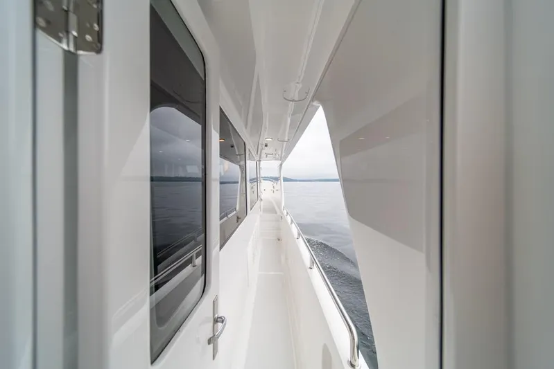 Smile Smile Smile Yacht Photos Pics Outer Reef 720 Motor Yacht 2022, sleek side deck view over calm waters.
