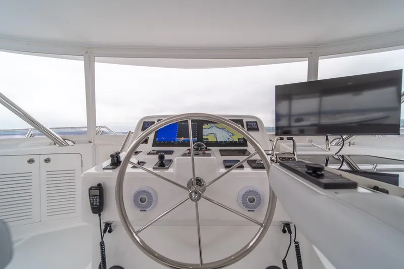 Smile Smile Smile Yacht Photos Pics 2022 Outer Reef 720 Motor Yacht helm with navigation screens and steering wheel.