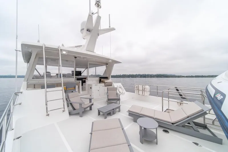 Smile Smile Smile Yacht Photos Pics Luxurious 2022 Outer Reef 720 Motor Yacht deck with lounge chairs and scenic water view.