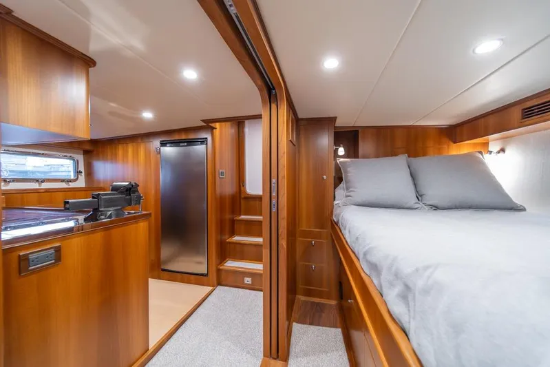 Smile Smile Smile Yacht Photos Pics Luxurious interior of 2022 Outer Reef 720 Motor Yacht with wood finish and cozy bedding.