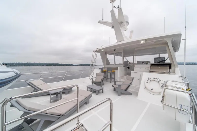 Smile Smile Smile Yacht Photos Pics Luxurious 2022 Outer Reef 720 Motor Yacht deck with lounge chairs and seating area.