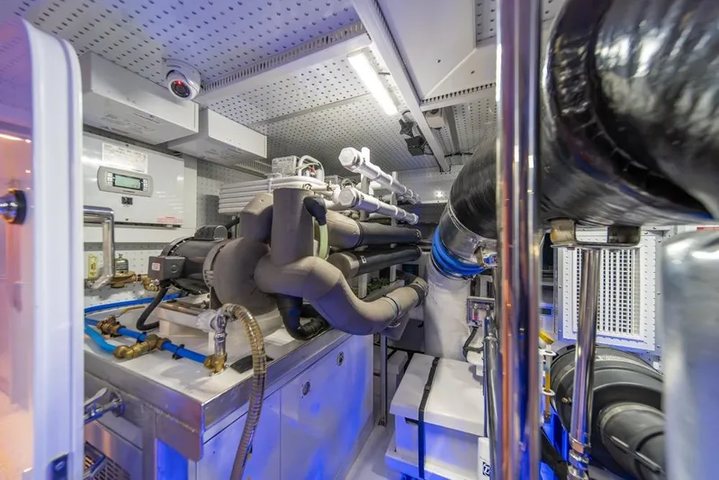 Smile Smile Smile Yacht Photos Pics Engine room of 2022 Outer Reef 720 Motor Yacht, showcasing complex machinery and piping.