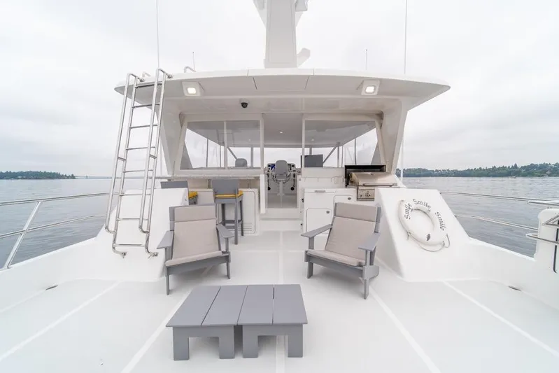 Smile Smile Smile Yacht Photos Pics 2022 Outer Reef 720 Motor Yacht deck with seating and ocean view.