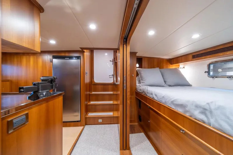 Smile Smile Smile Yacht Photos Pics Luxurious interior of 2022 Outer Reef 720 Motor Yacht with wood finish and cozy bedding.