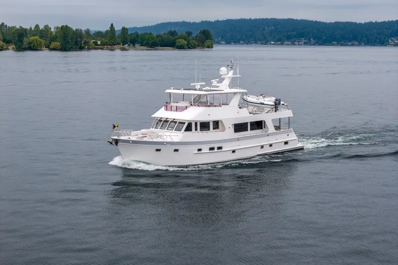 Smile Smile Smile Yacht Photos Pics 2022 Outer Reef 720 Motor Yacht cruising on a calm lake with forested shoreline.