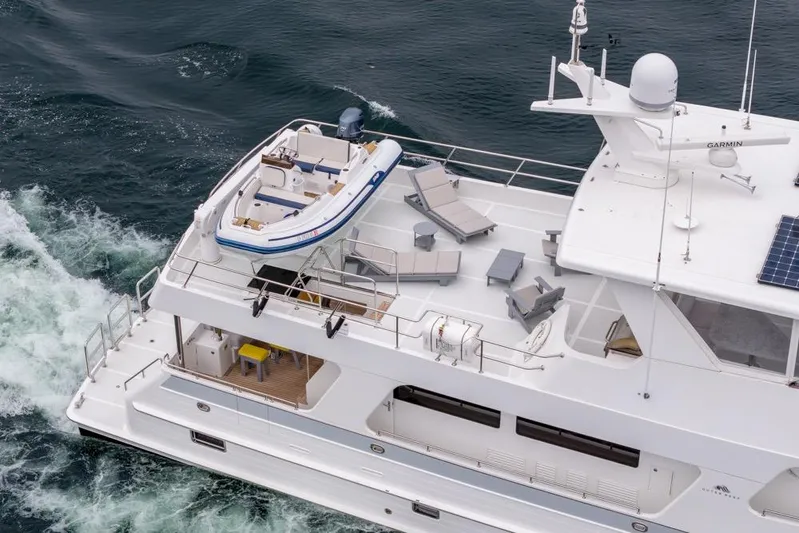 Smile Smile Smile Yacht Photos Pics 2022 Outer Reef 720 Motor Yacht with deck chairs and tender boat on open sea.