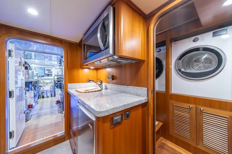 Smile Smile Smile Yacht Photos Pics 2022 Outer Reef 720 Motor Yacht interior with kitchen and laundry area.