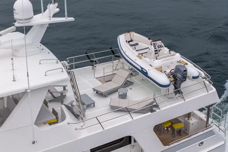 Smile Smile Smile Yacht Photos Pics 2022 Outer Reef 720 Motor Yacht with upper deck, tender, and lounge chairs.