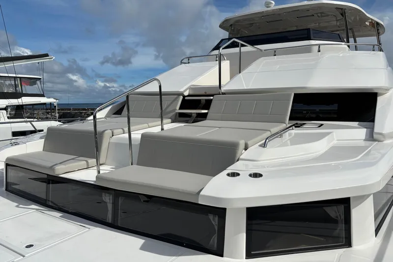  Yacht Photos Pics 2025 Aquila 54 Yacht with sleek design and spacious deck under a cloudy sky.