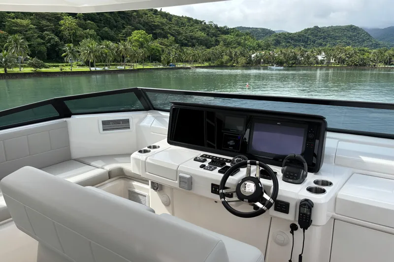  Yacht Photos Pics Helm of 2025 Aquila 54 Yacht with modern controls, overlooking serene tropical waters.