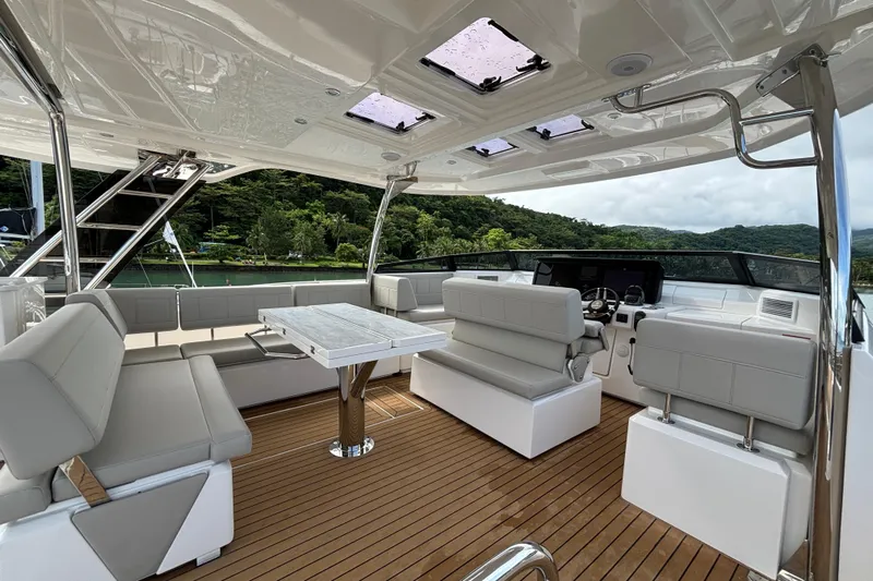  Yacht Photos Pics Luxurious 2025 Aquila 54 Yacht interior with sleek seating and modern helm, overlooking scenic waters.