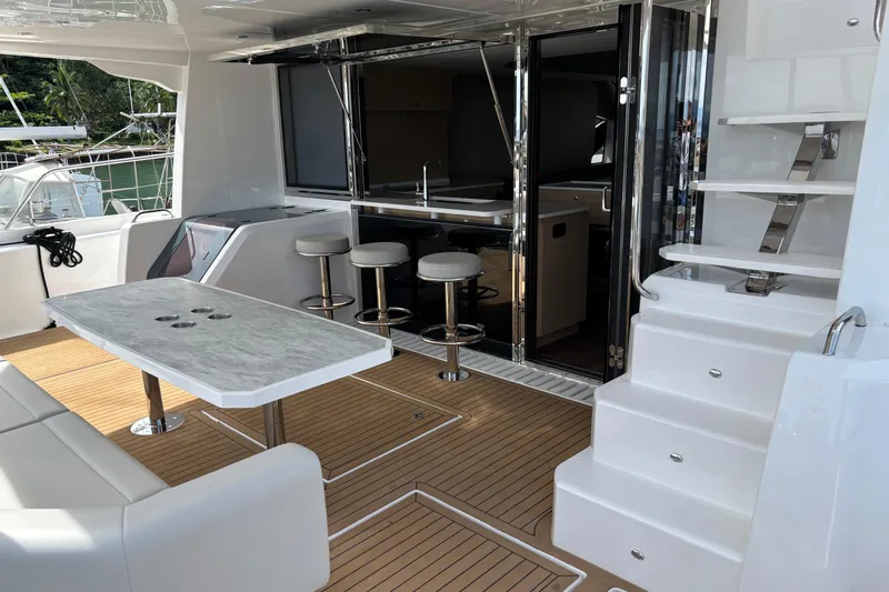  Yacht Photos Pics Luxurious 2025 Aquila 54 Yacht interior with modern seating, bar stools, and elegant staircase.