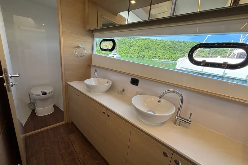  Yacht Photos Pics Luxurious bathroom on 2025 Aquila 54 Yacht with dual sinks and scenic window view.