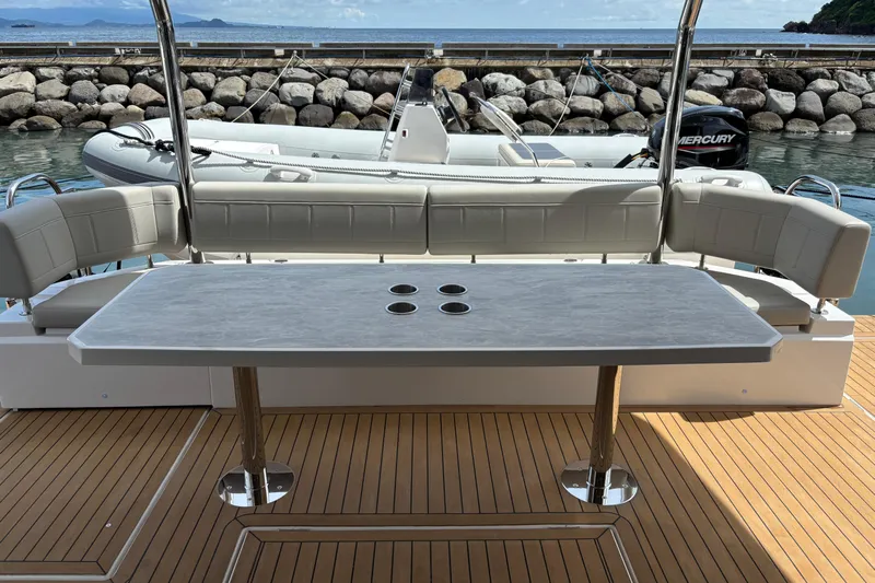  Yacht Photos Pics Luxury deck seating on 2025 Aquila 54 Yacht with elegant table and ocean view.