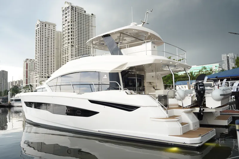  Yacht Photos Pics 2025 Aquila 54 Yacht docked in urban marina, with modern cityscape backdrop.