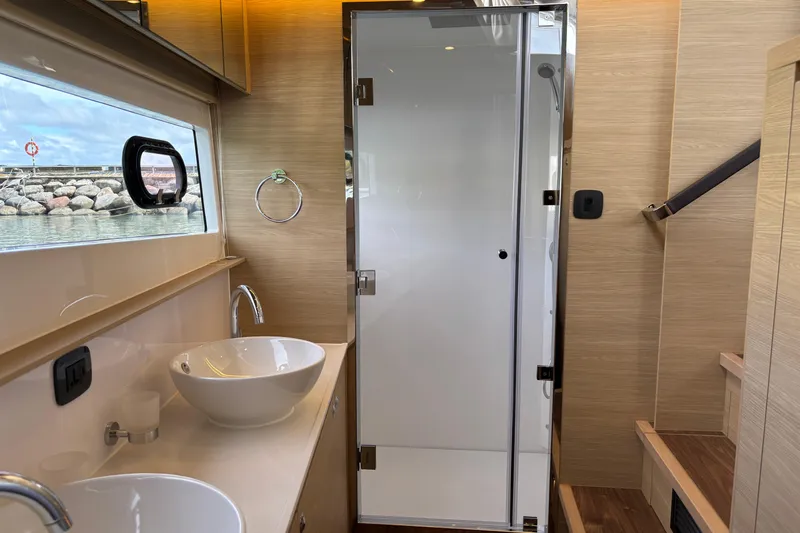  Yacht Photos Pics Luxurious bathroom interior of 2025 Aquila 54 Yacht with modern fixtures and ocean view.
