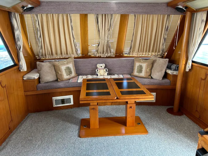 Broker Of Venice Yacht Photos Pics 1988 Sea Ranger aft cabin interior with cozy seating, wooden table, and decorative pillows.