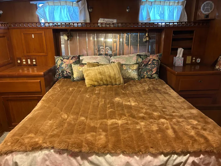 Broker Of Venice Yacht Photos Pics 1988 Sea Ranger aft cabin with cozy bed, plush blanket, and floral pillows in a wooden interior.