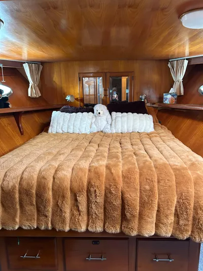 Broker Of Venice Yacht Photos Pics 1988 Sea Ranger aft cabin with cozy bed, plush bedding, and wood-paneled interior.