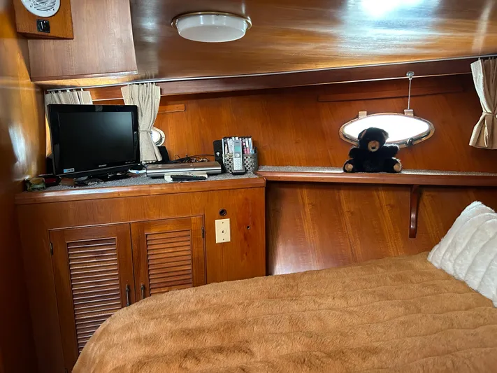 Broker Of Venice Yacht Photos Pics 1988 Sea Ranger aft cabin interior with wood paneling, TV, and plush bear on shelf.