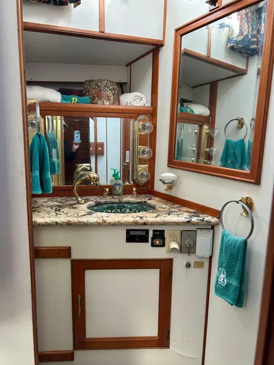 Broker Of Venice Yacht Photos Pics 1988 Sea Ranger aft cabin bathroom with granite countertop, mirror, and teal towels.