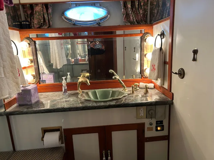 Broker Of Venice Yacht Photos Pics 1988 Sea Ranger aft cabin bathroom with marble countertop, brass fixtures, and oval porthole window.