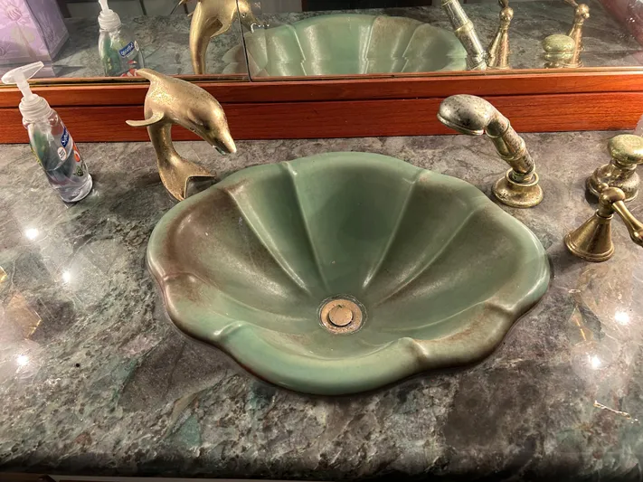 Broker Of Venice Yacht Photos Pics Green seashell sink with brass dolphin faucet on marble countertop, Sea Ranger aft cabin, 1988.