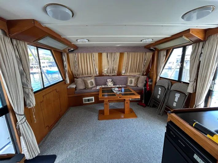 Broker Of Venice Yacht Photos Pics Interior of 1988 Sea Ranger aft cabin with seating, table, and windows.