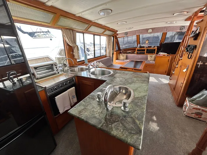 Broker Of Venice Yacht Photos Pics 1988 Sea Ranger aft cabin interior with kitchen, dining area, and large windows.