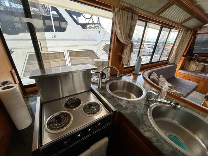 Broker Of Venice Yacht Photos Pics 1988 Sea Ranger aft cabin kitchen with stove, dual sinks, and marina view.