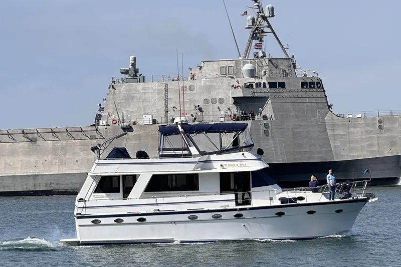 Broker Of Venice Yacht Photos Pics 1988 Sea Ranger aft cabin yacht cruising near a large naval ship.