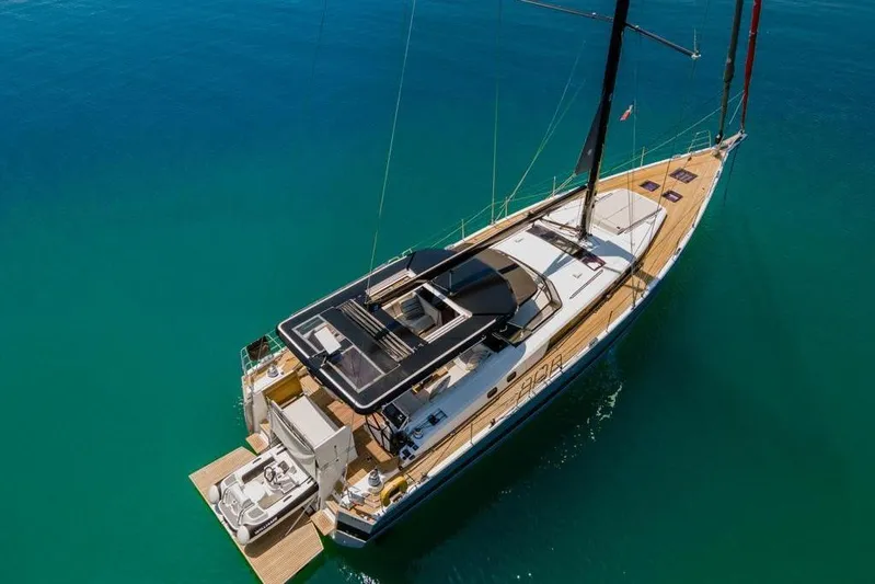 Dictador Yacht Photos Pics 2022 Beneteau Oceanis Yacht 62 sailing on clear blue water, aerial view.