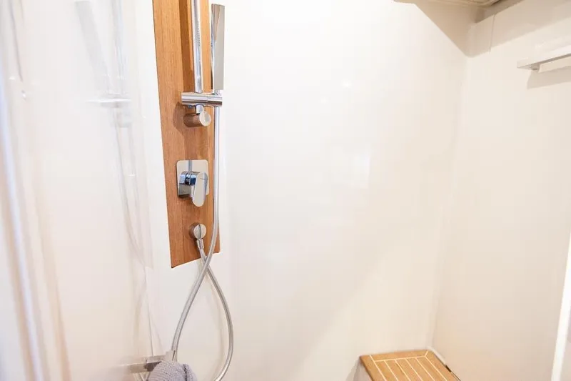 Dictador Yacht Photos Pics Shower area in 2022 Beneteau Oceanis Yacht 62 with wooden accents and modern fixtures.