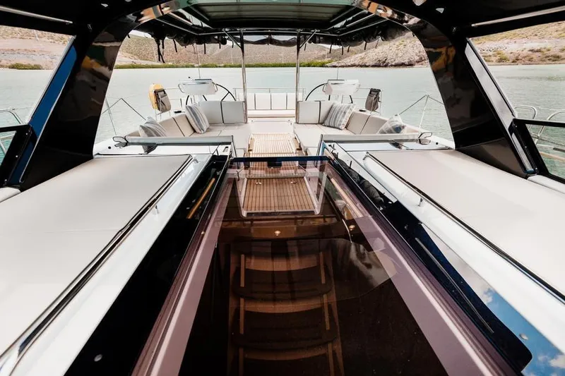 Dictador Yacht Photos Pics Luxurious 2022 Beneteau Oceanis Yacht 62 interior with elegant seating and scenic water view.