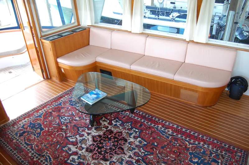 Shackleton Yacht Photos Pics Interior of 1982 Miller Marine North Sea Trawler with sofa, glass table, and patterned rug.