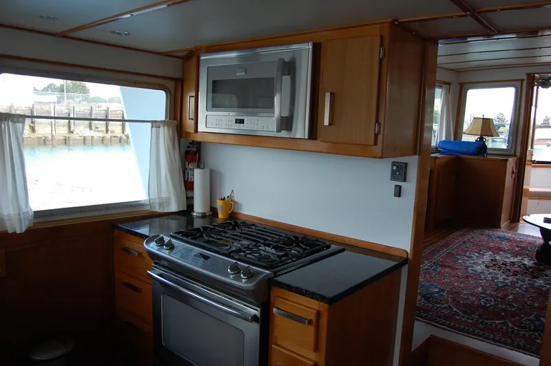 Shackleton Yacht Photos Pics Kitchen area of 1982 Miller Marine North Sea Trawler with stove, microwave, and window view.