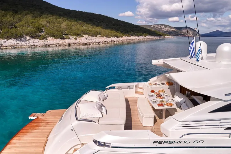 For Ever Yacht Photos Pics Luxurious 2008 Pershing 80 yacht with elegant deck dining, anchored in serene turquoise waters.