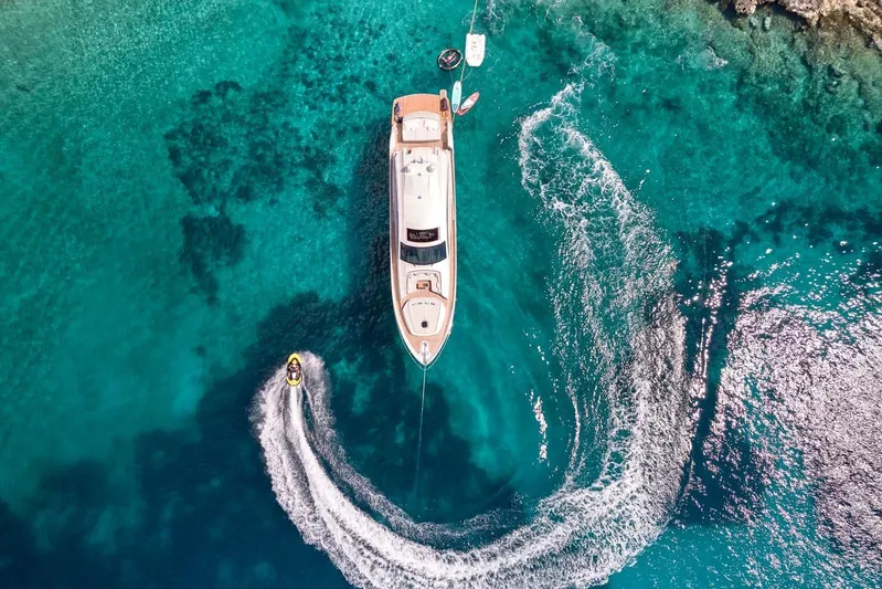 For Ever Yacht Photos Pics Aerial view of 2008 Pershing 80 yacht with jet ski in turquoise waters.