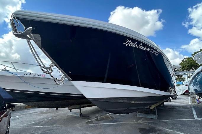 2017 Intrepid boat named "Little Emina" on display under a blue sky.