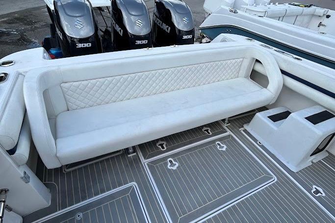 2017 Intrepid boat with white seating and Suzuki 300 engines on deck.