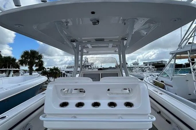 2017 Intrepid boat with rod holders, docked at marina under cloudy sky.