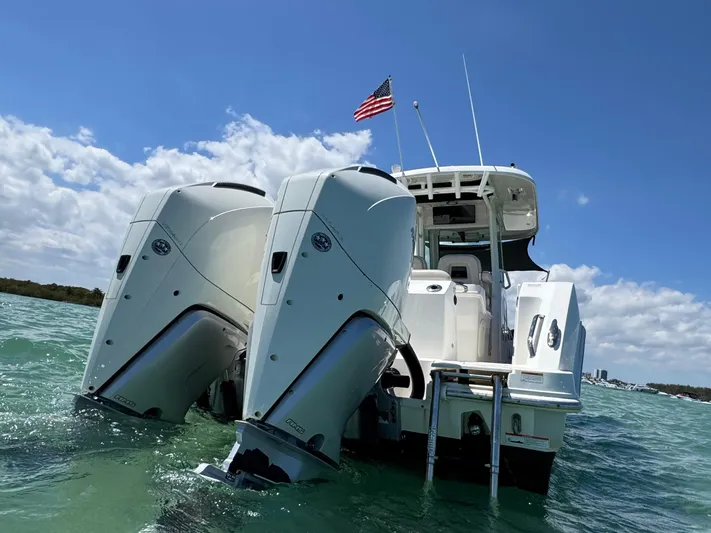  Yacht Photos Pics 2020 Boston Whaler 280 Outrage boat with dual engines on water, American flag flying.
