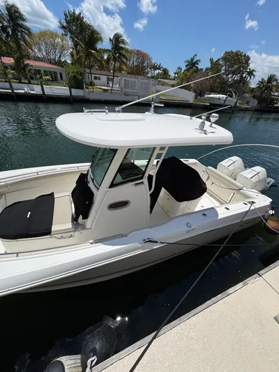  Yacht Photos Pics 2020 Boston Whaler 280 Outrage docked by a canal with palm trees.