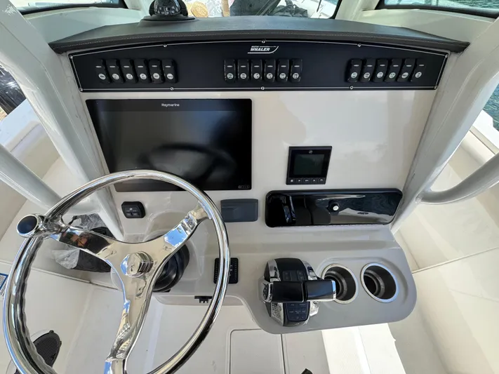  Yacht Photos Pics 2020 Boston Whaler 280 Outrage helm with steering wheel, controls, and navigation display.