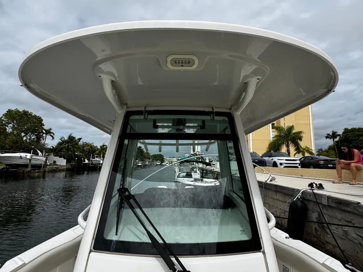  Yacht Photos Pics 2020 Boston Whaler 280 Outrage boat docked by a canal with palm trees.