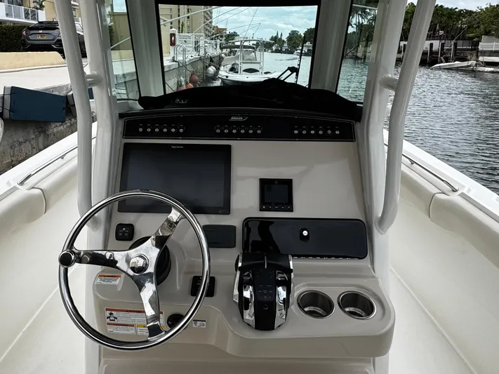  Yacht Photos Pics 2020 Boston Whaler 280 Outrage boat console with steering wheel and navigation controls.